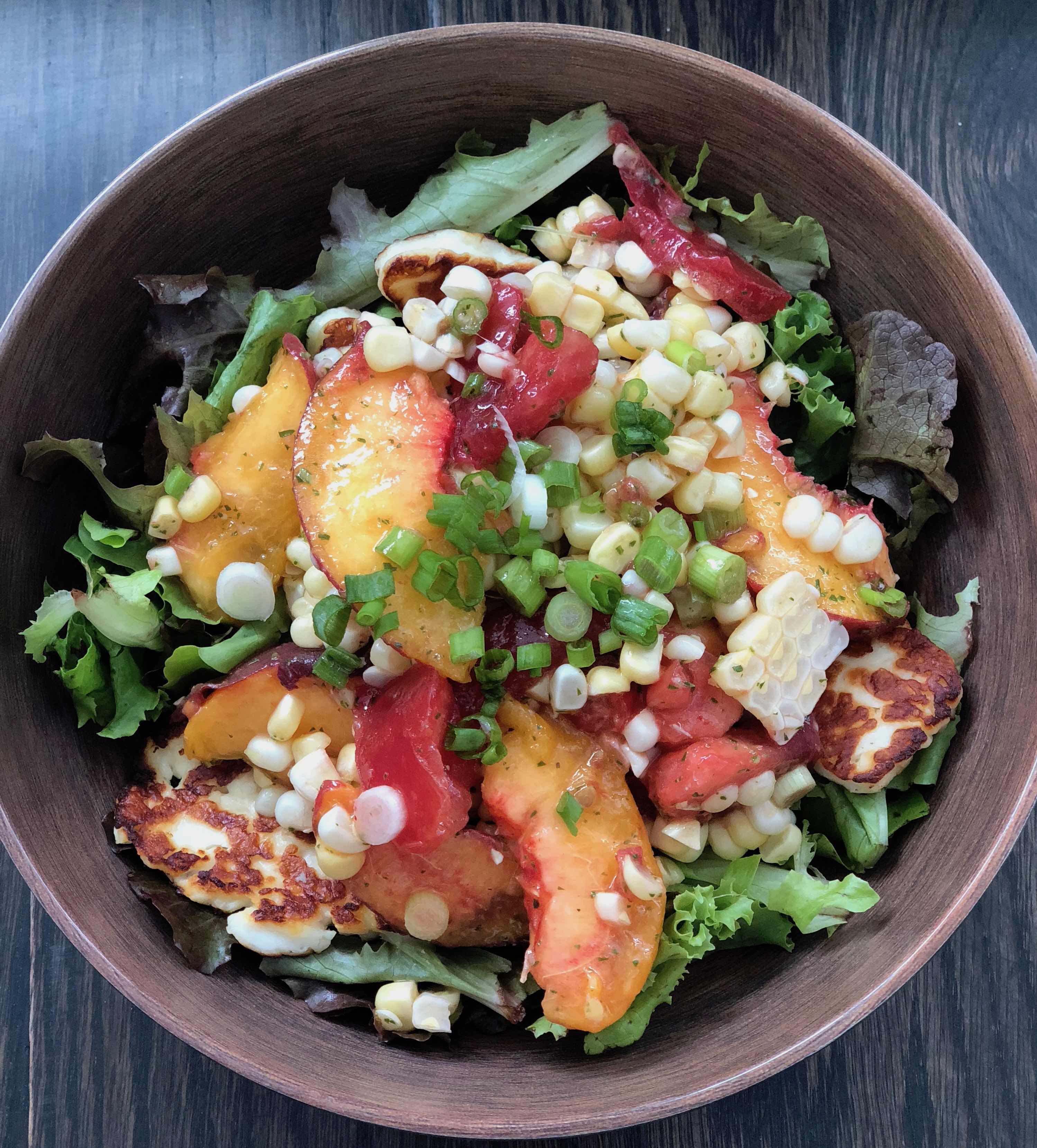 Destined to become your favorite healthy summer salad, this recipe features fresh sweet corn, juicy sweet peaches and tomatoes with a lemon basil vinaigrette. It's Paleo, Whole30, Sugar-Free, Gluten-Free and Vegetarian. | www.amiofbs.com